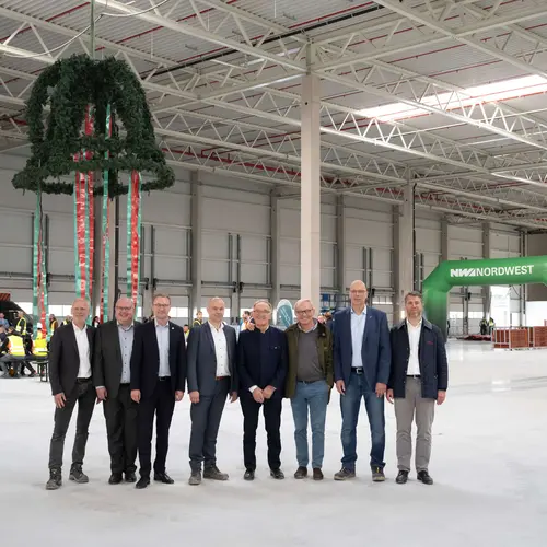 Offizielle vor dem Richtkranz in einer Halle des neuen Zentrallagers