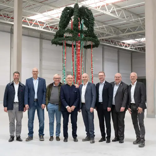 Offizielle vor dem Richtkranz beim Richtfest für das neue Logistikzentrum